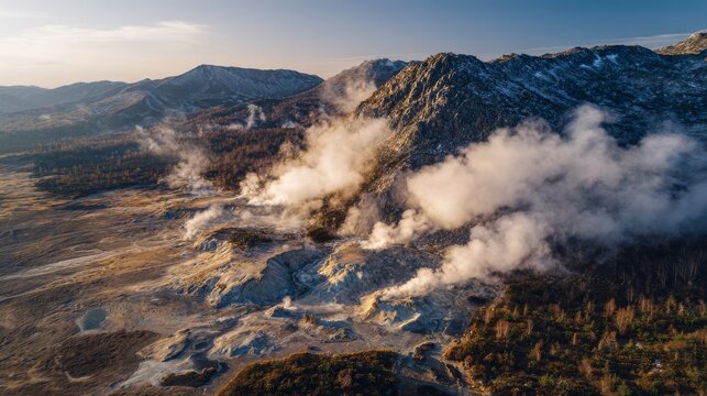 An aerial view showcases a geothermal landscape with steaming vents, snow-dusted mountains, and autumn foliage under a golden sunset