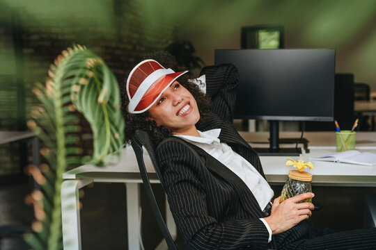 Businesswoman enjoying a summer cocktail and relaxing at office