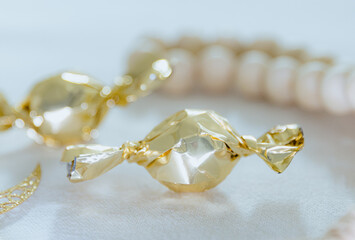 Two candies in a gold wrapper on a white kitchen table.