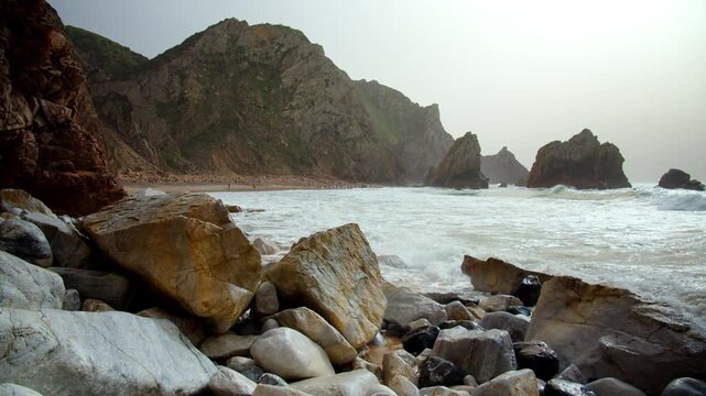Beautiful rocky coast on the Atlantic coast. The famous Portuguese Ursa Beach. Beautiful panorama of the Rocky shore with incoming turquoise waves. Beautiful seascape on the background of rocks.