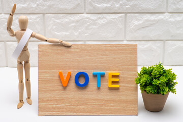 タスキを掛けた選挙の候補者と投票を促す看板