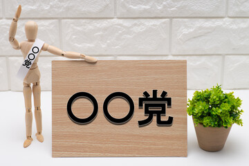 政党名のタスキを掛けた選挙の候補者と政党の看板