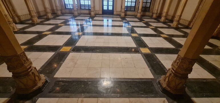 Grand interior hall of Lalbagh Palace in Indore featuring ornate classical columns and a beautiful geometric marble floor design