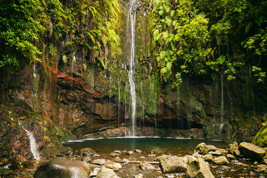 Madeira, Portugal - December 7, 2025: The famous 25 Fontes waterfall (Levada das 25 Fontes) cascading into a lagoon surrounded by lush Laurisilva forest.