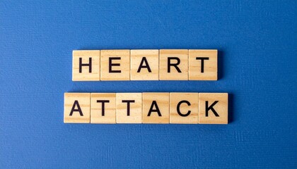 Wooden tiles spelling heart attack on blue background surface with scrabble style letters emphasizing medical condition concept and design