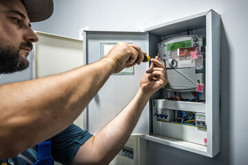 Electrician Installing electricity counter in switchbox. current breaker installation