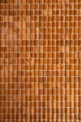 Brown ceramic architectural tiles creating rhythmic wall pattern