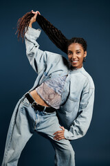 Confident young woman showcasing stylish denim attire in a vibrant studio setting