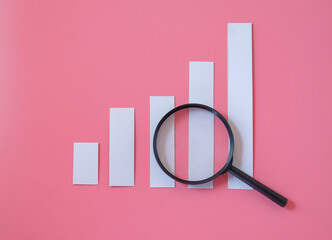 A magnifying glass with charts graphic bar. Financial development.