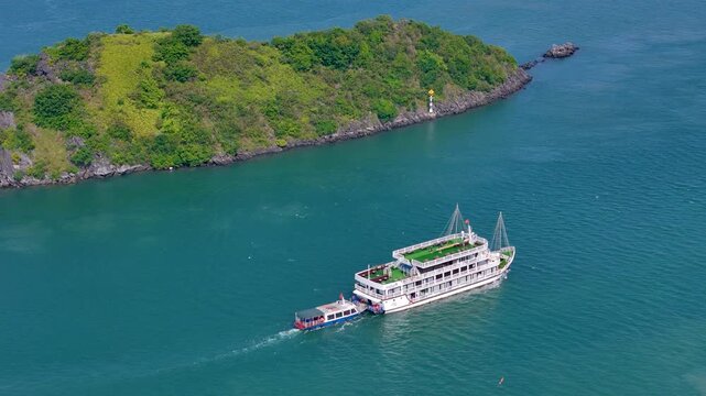 Boat exploring the dramatic karst landscape of Ha Long Bay, with emerald waters and towering rock pillars creating a breathtaking maritime panorama.