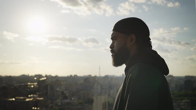 Young man thinking about relationship problems while looking at city rooftop