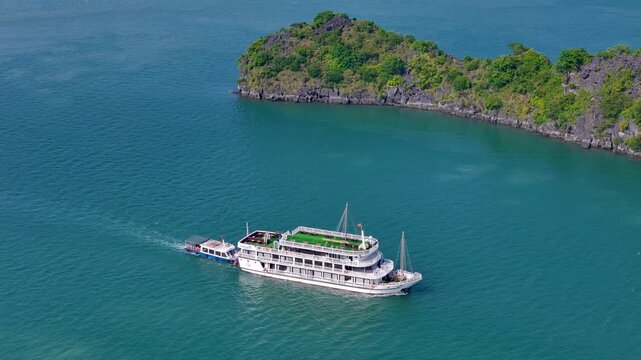 Boat exploring the dramatic karst landscape of Ha Long Bay, with emerald waters and towering rock pillars creating a breathtaking maritime panorama.