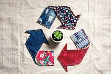 Obraz premium Recycling symbol made from fabric patches with succulent plant