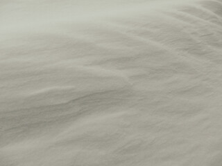 Obraz premium Abstract white snow texture with wind-blown ripples and soft shadows