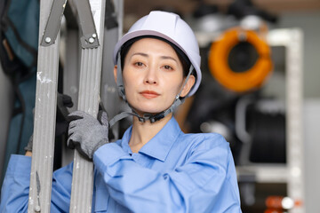 女性　作業員　メンテナンス　脚立　工事
