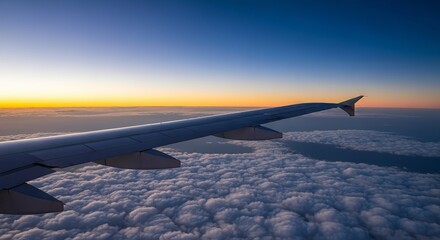 Obraz premium Breathtaking Airplane Wing View Above Soft Clouds During Stunning Sunset or Sunrise Over Horizon