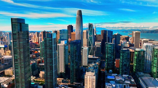 Aerial view on the modern glass skyscrapers in the San Francisco financial district, including the Salesforce Tower. The urban landscape extends towards the bay in the distance.