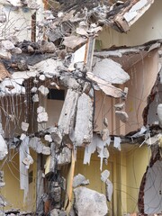 Exposed Rebar and Concrete Hanging from Partially Demolished Building. Dangerous Demolition Scene with Swinging Rebar and Rubble. Collapsed Structure with Hanging Metal and Concrete Fragments.