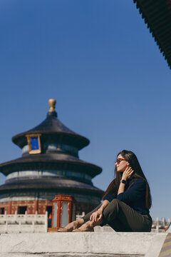 brunette girl sitting on the steps by temple of heven in China