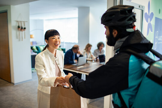 Businesswoman receiving food delivery in modern office
