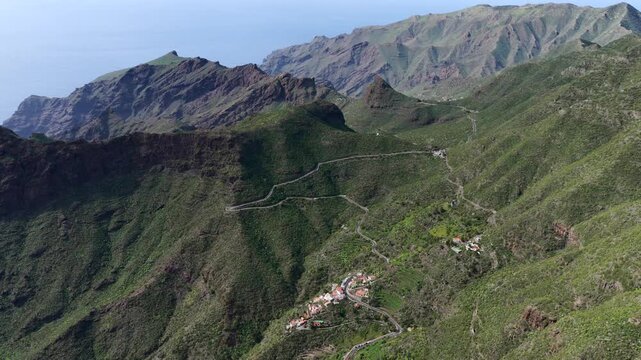 Cinematic aerial of the winding mountain road switchbacks leading to Masca village in Teno Rural Park Tenerife