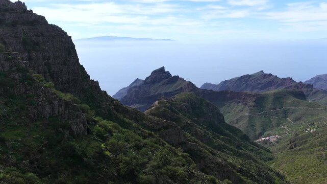 Cinematic aerial of the winding mountain road switchbacks leading to Masca village in Teno Rural Park Tenerife