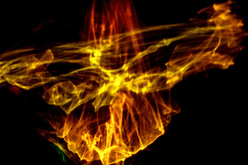 Fototapeta premium Abstract colorful smoke patterns in shades of yellow, orange, and green against a black background, creating a dynamic visual effect and fluid motion