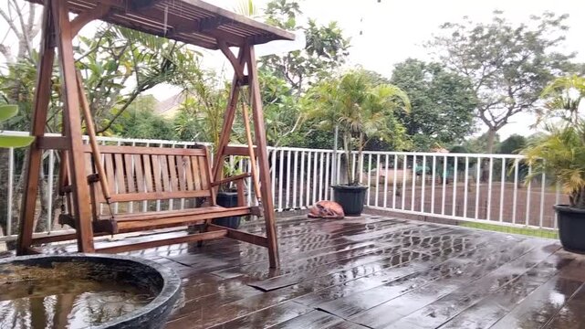 Depok, Indonesia - Jan 12, 2026. The simple beauty of rain on a wooden chair