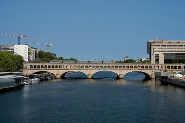 Fototapeta premium Paris, France - 08 15 2025: View of the aerial subway on Bercy Bridge with a subway train in summer