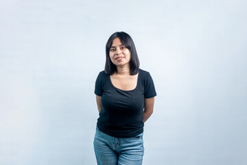 Friendly studio portrait of a young Southeast Asian female looking at camera with a warm smile. Clean shot isolated on a light grey background. © Ryan