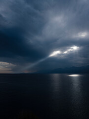 Dramatic light beams between clouds above ocean