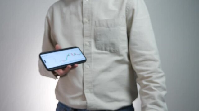 A dynamic contrast between tangible and digital wealth. This shot captures a modern individual presenting physical cash before transitioning to a smartphone screen showing a portfolio value and