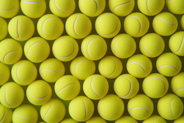 Numerous bright yellow tennis balls stacked closely together