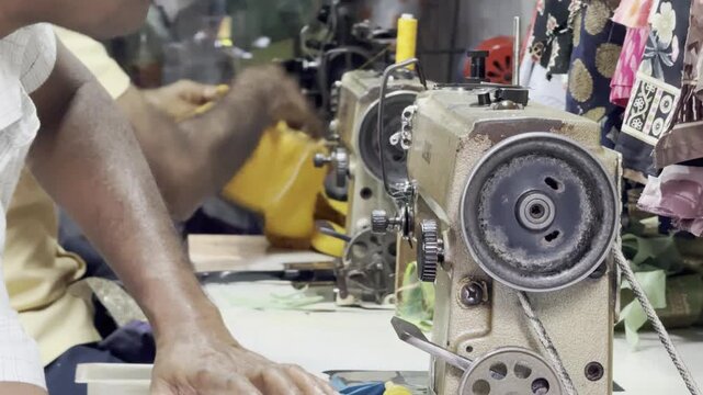 Dharavi, Mumbai, India &ndash; January 29, 2026: Worker using a mechanical sewing machine for garment production in a small urban workshop environment.