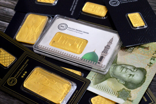 Cairo, Egypt, February 6 2026: CNY Chinese Yuan money and 24K karat BTC Bullion Trading Center pure yellow gold bars The prophet mosque in Medina, Pharaonic, King Tutankhamun and Kaaba door