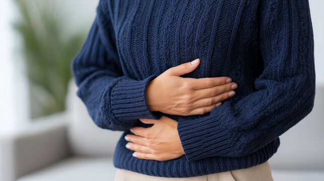 Woman holds her stomach, concept of abdominal pain and menstrual cramps. Healthcare or medical advertisement for pain relief product.