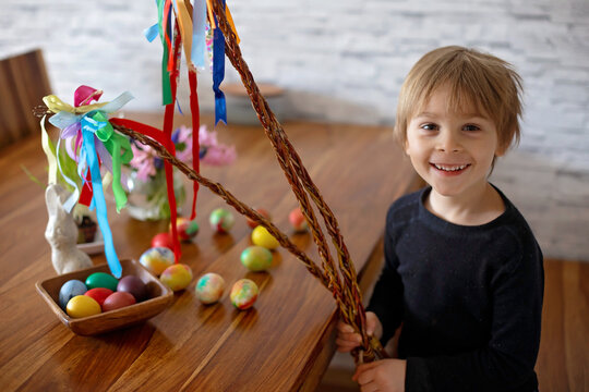 Little blond toddler boy child coloring easter eggs at home, Czech Republic tradition