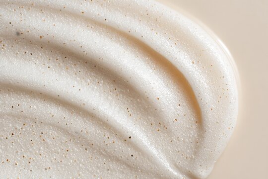 Creamy exfoliating face scrub texture with natural microbeads close-up