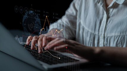 Close-up view of hands typing on a laptop, featuring digital graphs and charts. Ideal for visuals...
