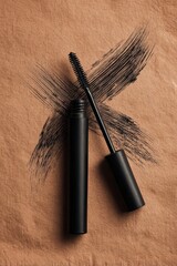 Naklejka premium Black mascara tube with brush on brown textured background