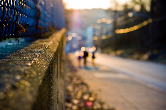 Blurredf Family walks down city sidewalk at sunset