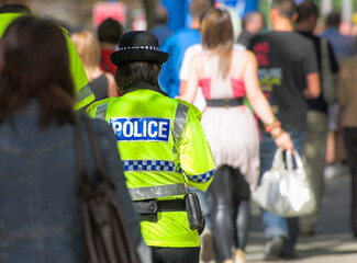 Female police officer patrolling a street in  the Uk. © hubb67