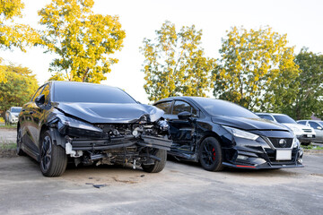 Scene of two black cars collided at the front in a parking lot.