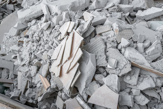 Discarded ceramic tiles and masonry rubble in a metal waste container