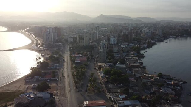 Aerial drone footage of Lecher&iacute;a waterfront skyline with modern residential towers and calm Caribbean waters at golden hour.