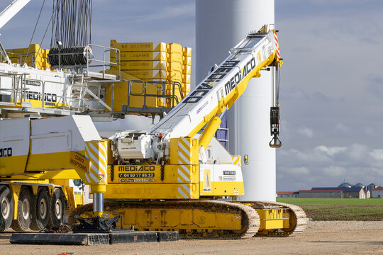 Lemoncourt, France - November 11th 2025 : View on a white and yellow telescopic crawler crane Liebherr LTR 1100 on a construction site of a wind farm with a lattice boom crane Liebherr LG 1750 behind.