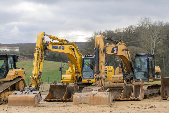 Ludres, France - January 6th 2022 : View on a two yellow crawler excavators, a Caterpillar and a Komatsu, for earthworks on a construction site.
