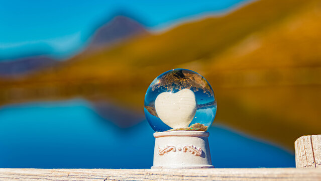Crystal ball, with a heart inside, alpine autumn or indian summer landscape with reflections in a lake and Mount Grosser Rettenstein at Mount Resterkogel, Mittersill, Oberpinzgau, Salzburg, Austria