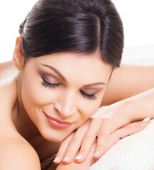 Beautiful, young and healthy woman on bamboo mat in spa salon is having massage. Isolated on white. Spa, health and healing concept.