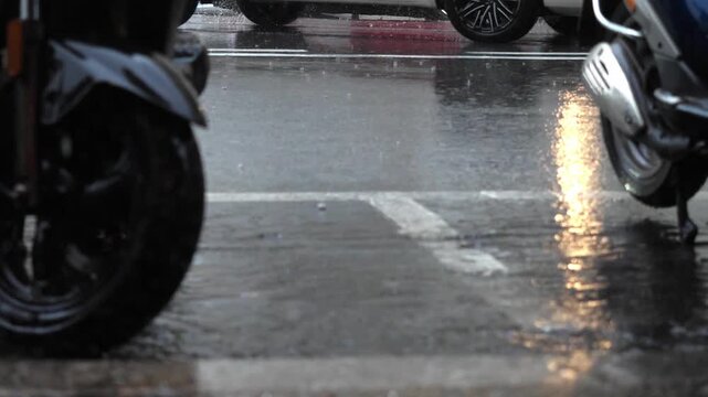 Thunderstorm with heavy rain falling on city asphalt, intense precipitation hitting the urban road surface.